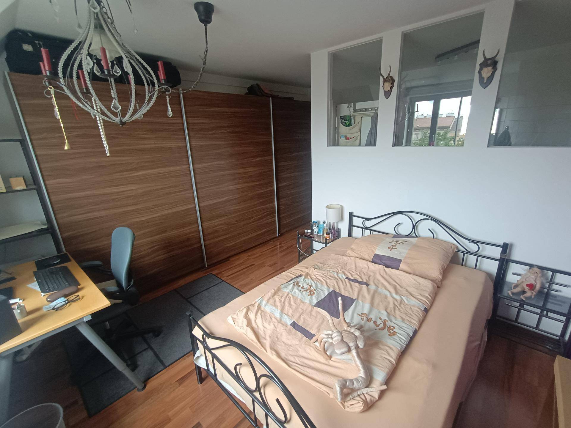 Schlafzimmer mit Holzboden, großem Bett und geräumigen Einbauschränken.