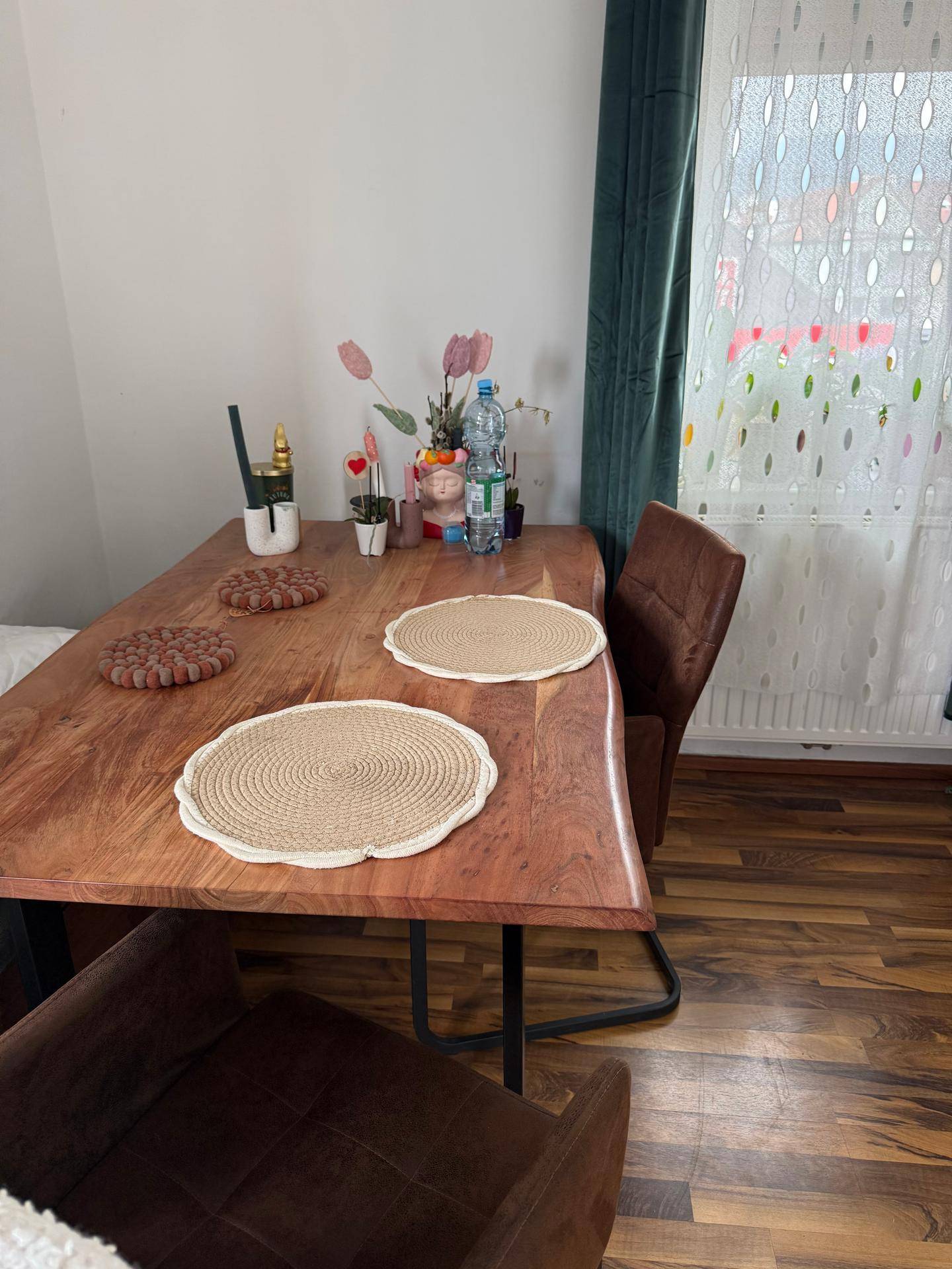 Detailaufnahme eines Holztisches mit Dekoration und bequemen Esszimmerstühlen.