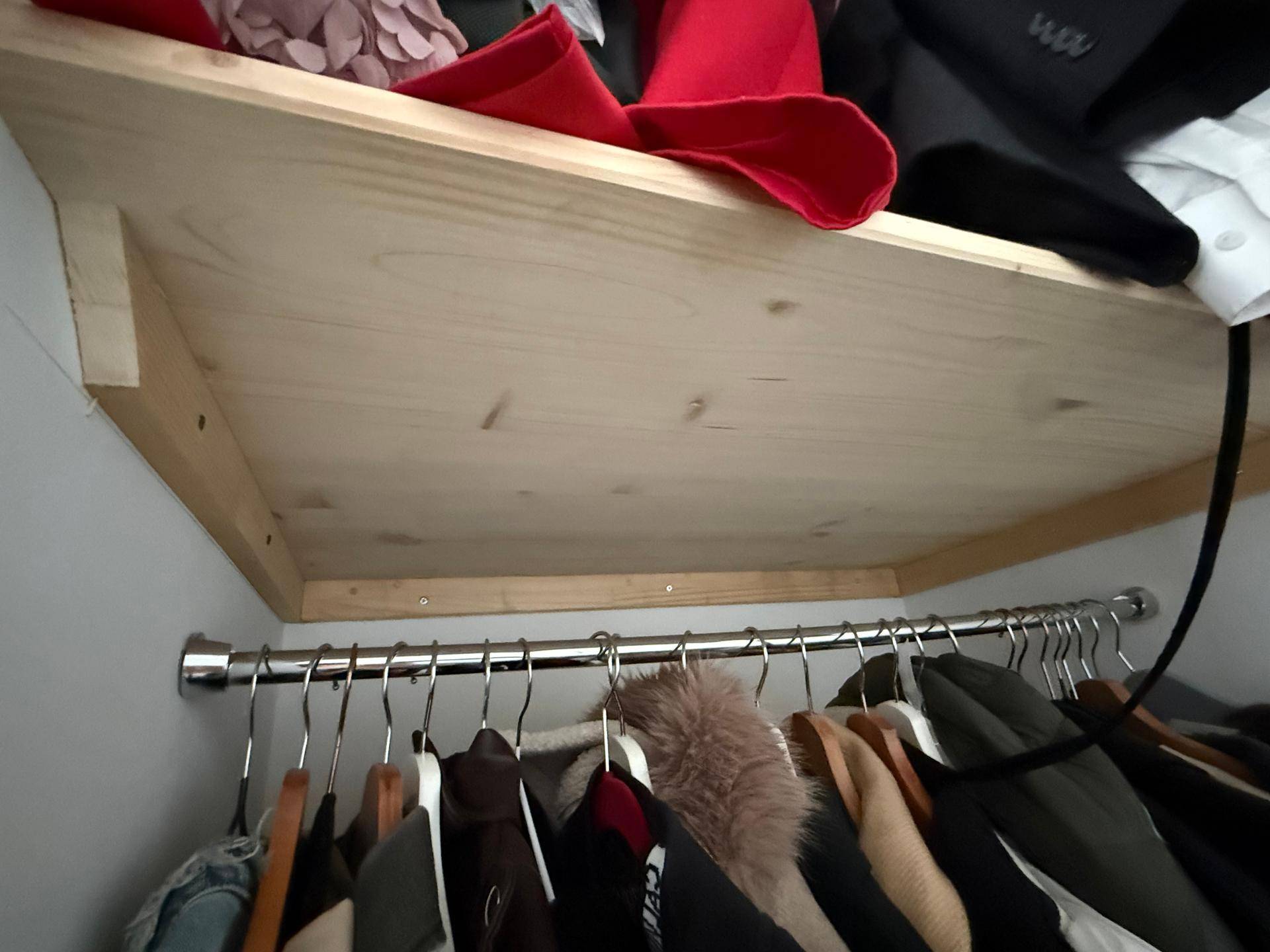Kleiderschrank mit Kleiderstange und Holzregal, bietet praktischen Stauraum für Kleidung.
