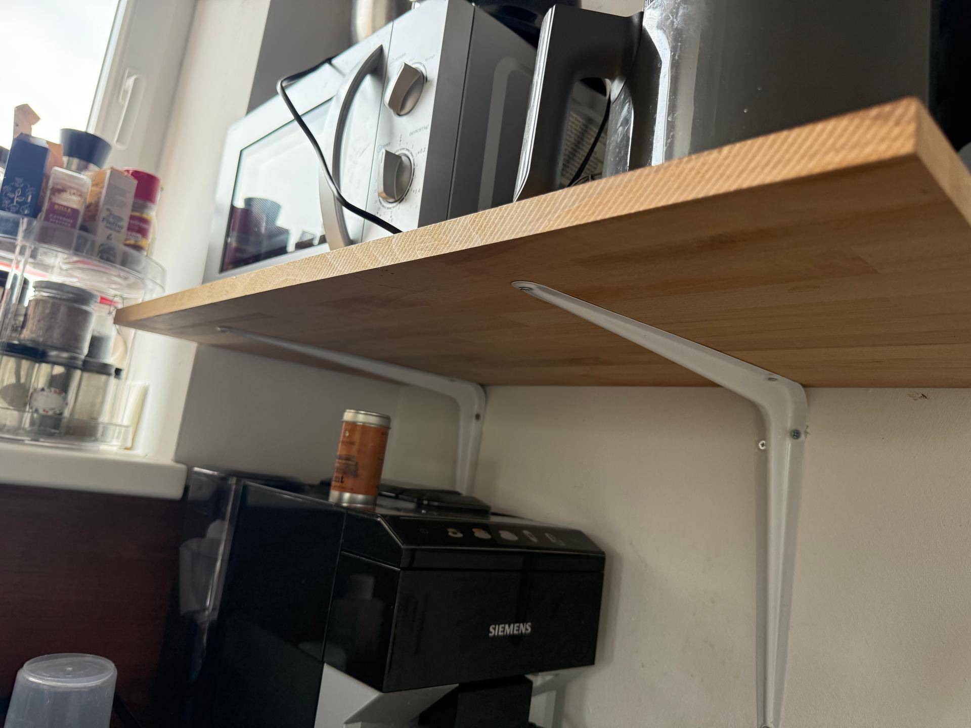 Küchenregal mit Mikrowelle und Kaffeemaschine, bietet zusätzlichen Stauraum.