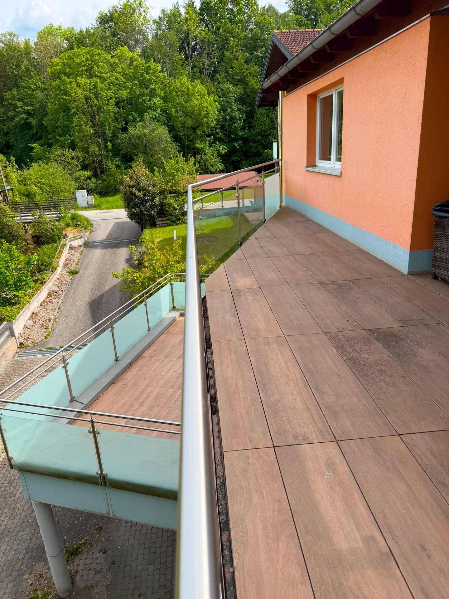 Geräumiger Balkon mit Glasgeländer und weitem Blick in die Natur.