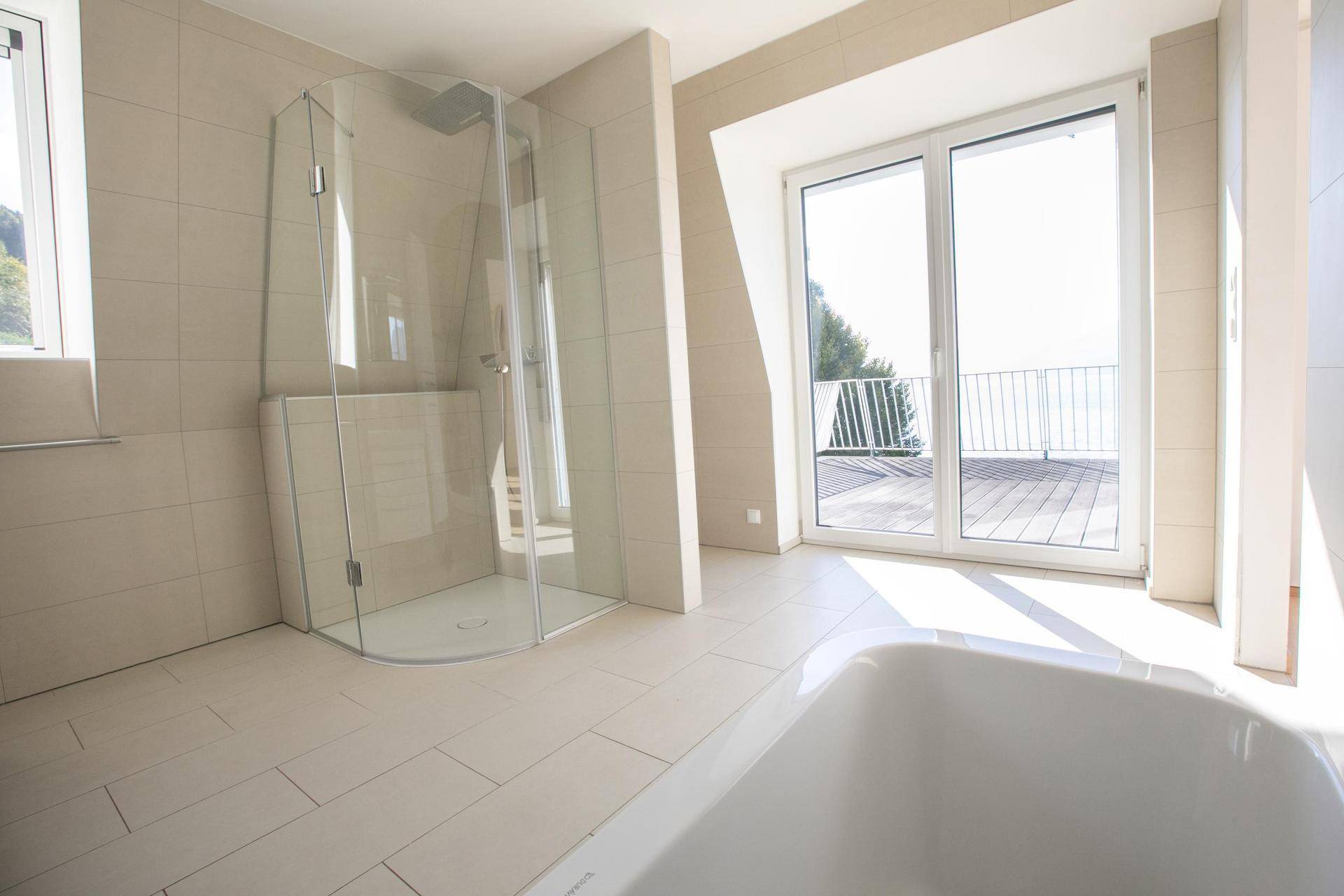 Geräumiges Badezimmer mit Dusche, Badewanne und Zugang zu einer großen Dachterrasse.
