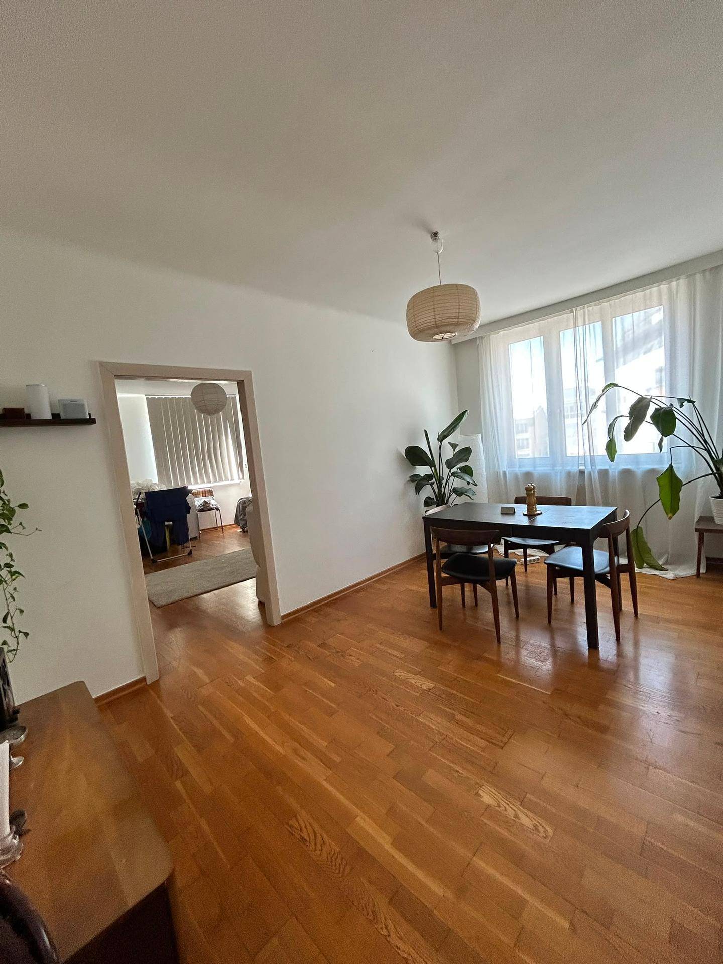 Heller Essbereich mit Holztisch, Stühlen und großem Fenster, das viel Licht spendet.