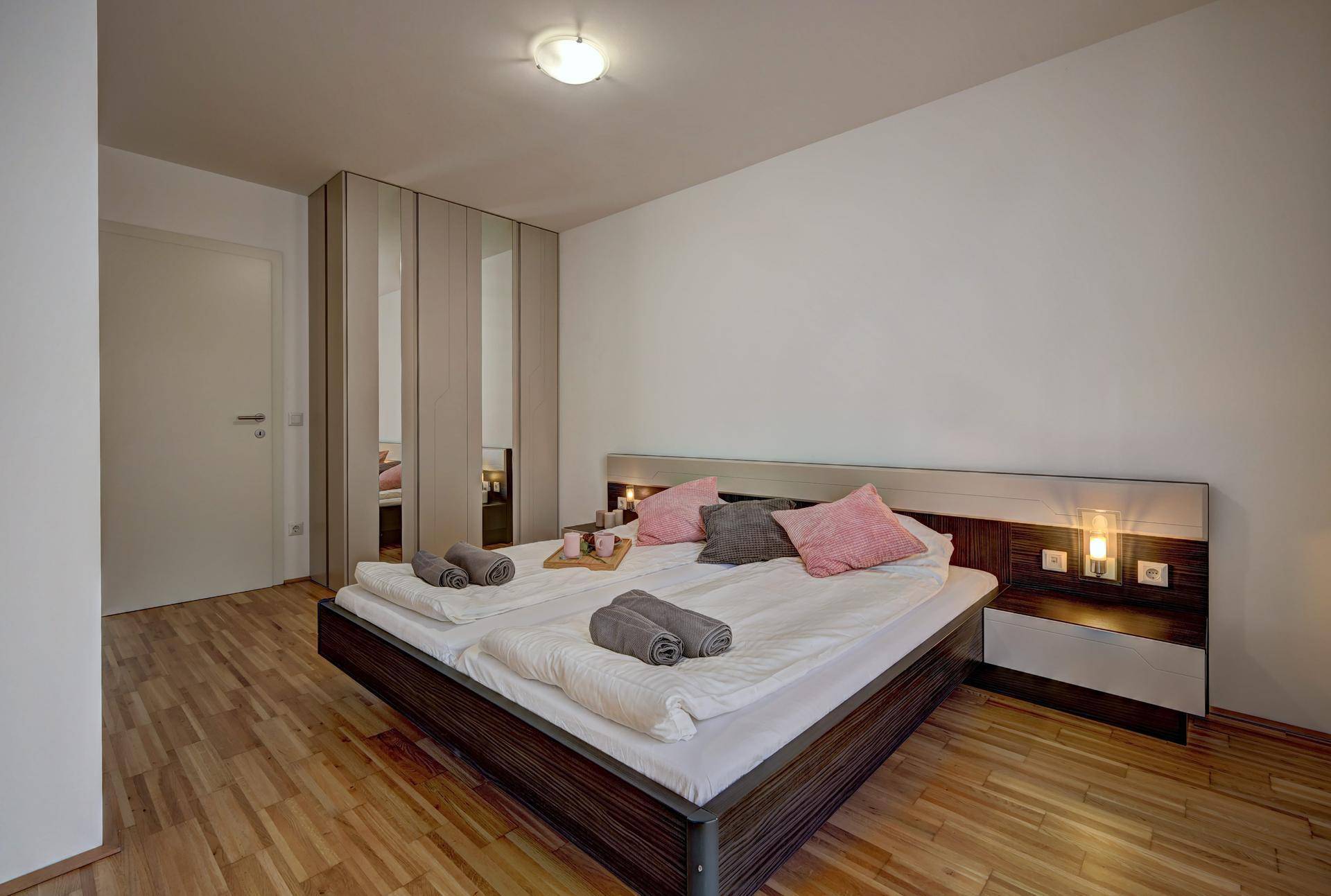 Gemütliches Schlafzimmer mit Doppelbett, Holzfußboden und einem praktischen Einbauschrank.