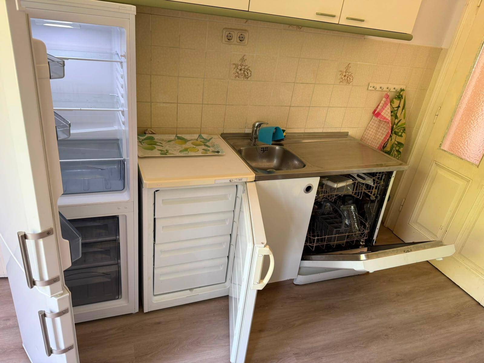 Nahaufnahme von Kühlschrank, Gefrierschrank und Geschirrspüler in einer funktionalen Küche.