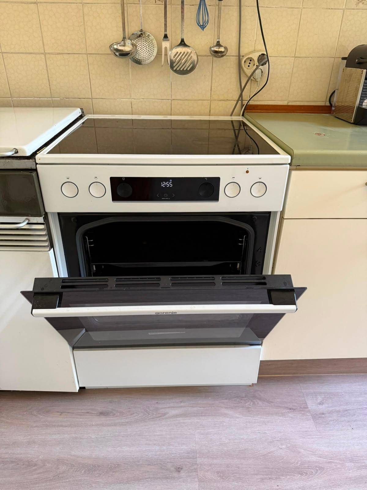 Nahaufnahme eines modernen Backofens mit Cerankochfeld in einer Küche mit Laminatboden.