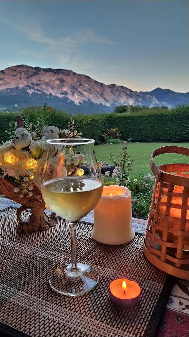 Gemütlicher Abend auf der Terrasse mit Wein, Kerzen und Blick auf die Berge.