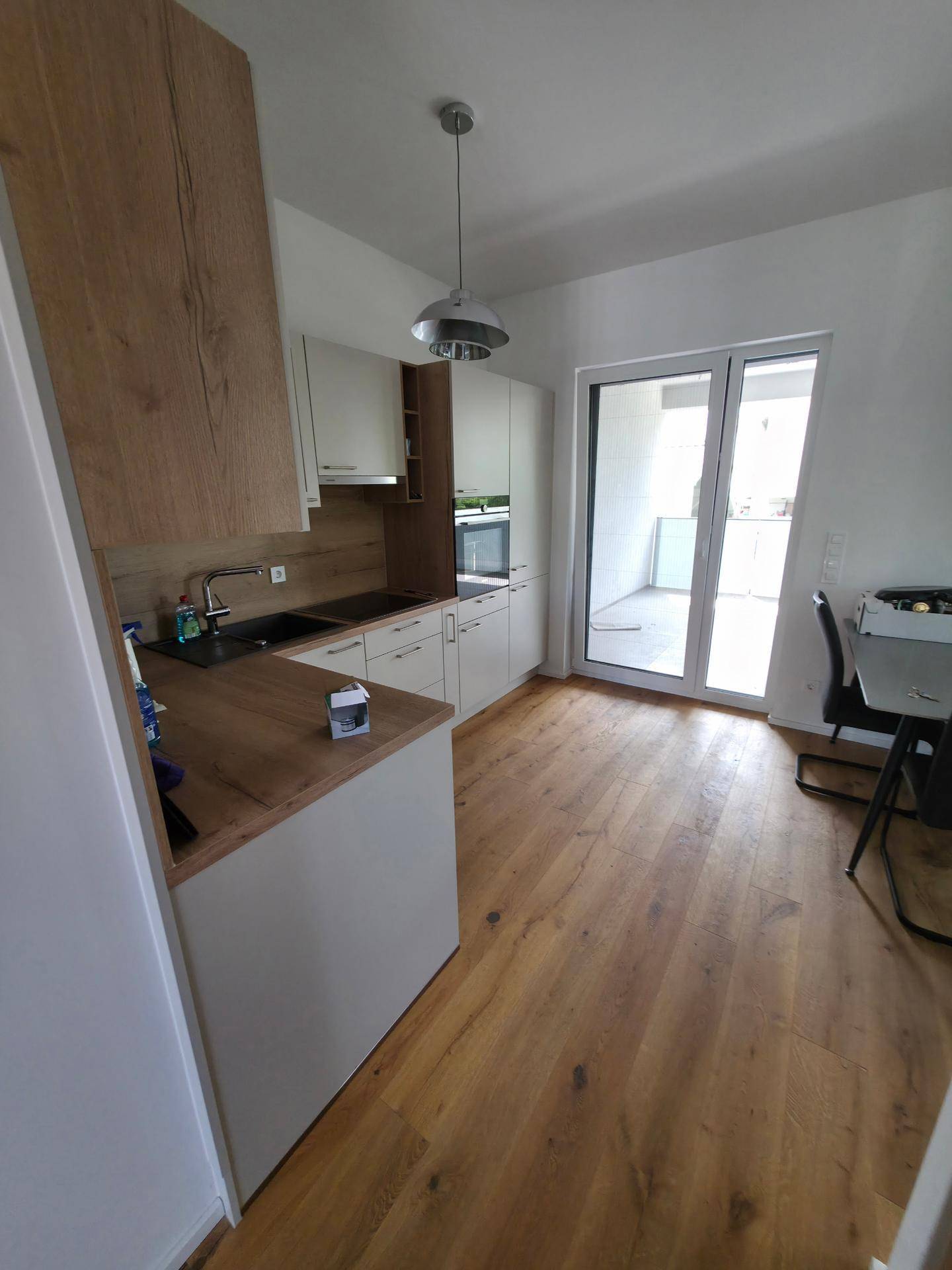Helle Küche mit Holzboden und direktem Zugang zu einem Außenbereich.