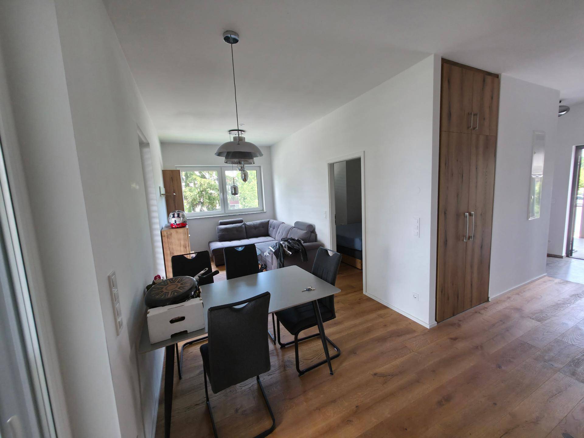 Offener Wohn- und Essbereich mit Holzboden und Blick in den Wohnbereich.