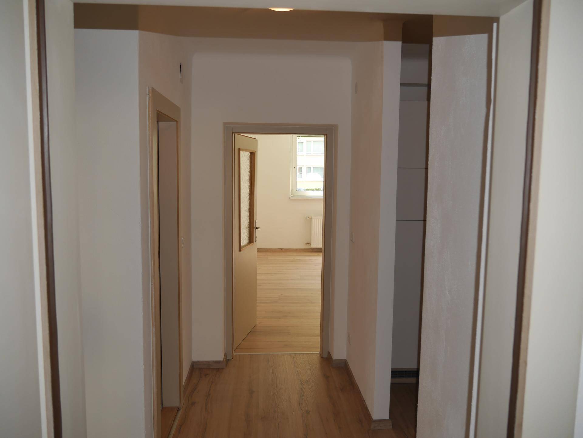 Heller Flur mit Laminatboden und Türen zu den angrenzenden Zimmern.
