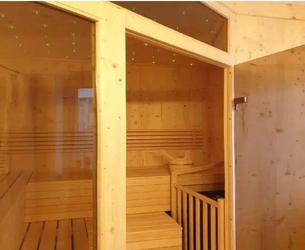 Innenansicht einer modernen Holzsauna mit Sitzbänken und Beleuchtung.