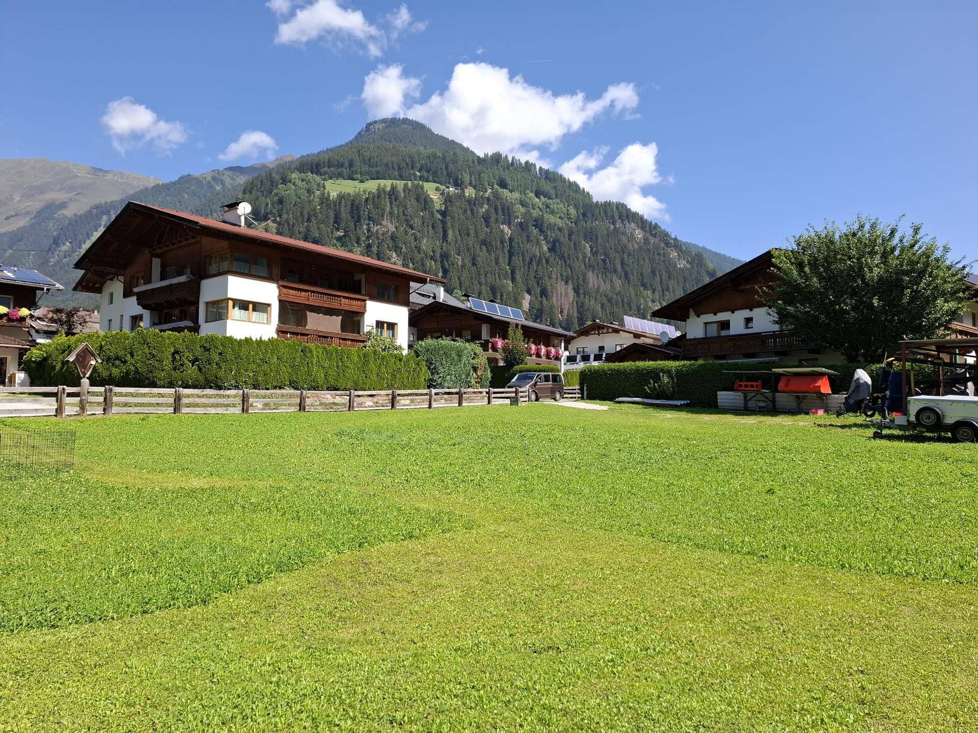 Traditionelle Häuser in den Alpen mit einem majestätischen Berg im Hintergrund.