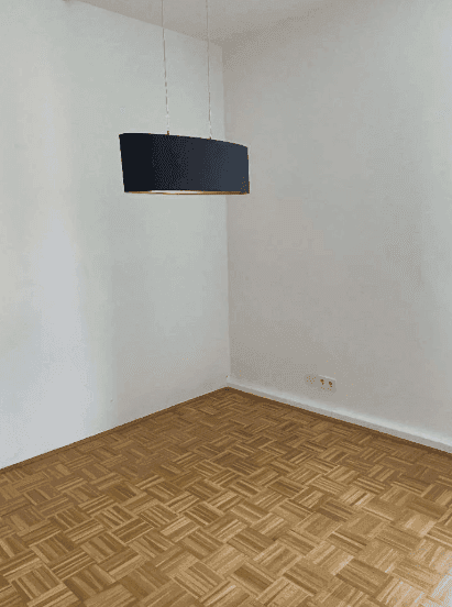 Helles Zimmer mit Parkettboden und moderner Deckenleuchte, vielseitig nutzbar.