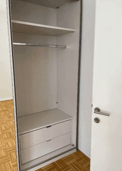Eingebauter Kleiderschrank mit Regalen und Kleiderstange, praktisch für Stauraum.