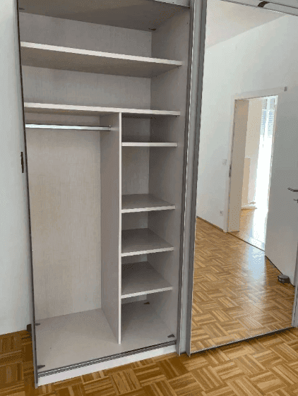 Offener Einbauschrank mit mehreren Fächern und Kleiderstange, ideal für Organisation.