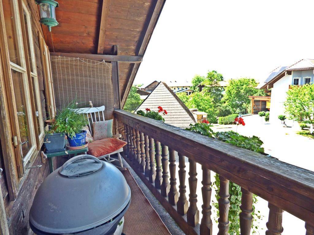 Gemütlicher Balkon mit Grill und Blick auf die umliegenden Häuser und Natur.