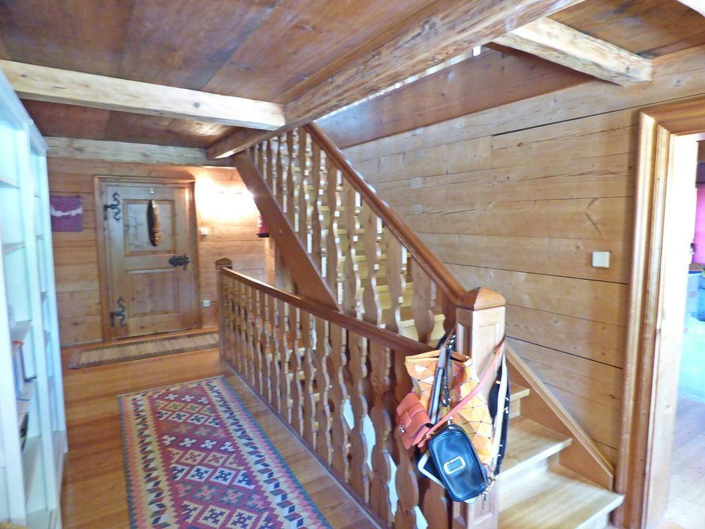 Traditioneller Holzflur mit geschnitztem Treppengeländer und Holzwänden.