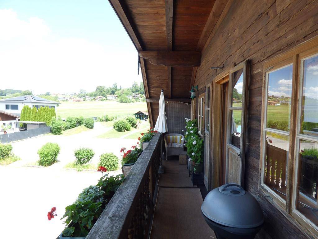 Langer Holzbalkon mit Blumenkästen und weitem Blick über die Landschaft.