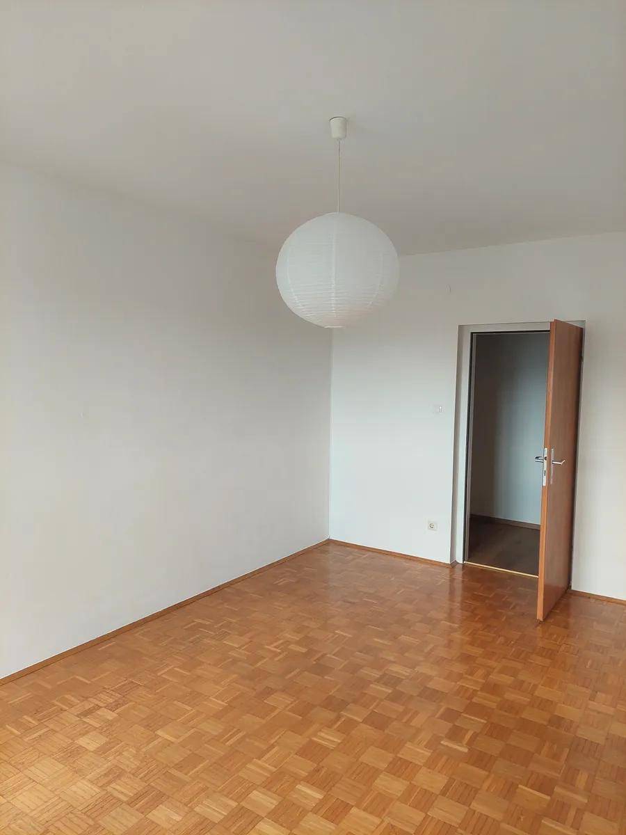 Leerer Raum mit Parkettboden und weißen Wänden, bereit zur individuellen Gestaltung.