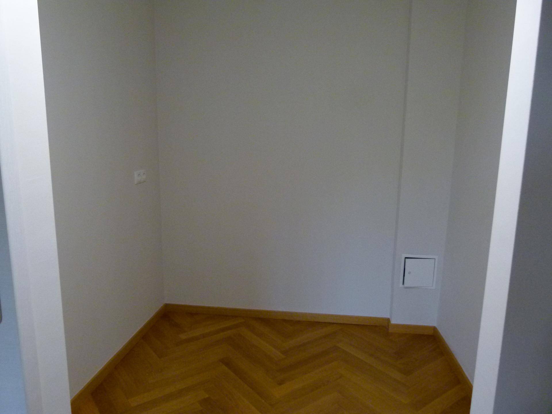 Kleiner Raum mit Parkettboden und weißen Wänden, ideal als Abstellkammer nutzbar.