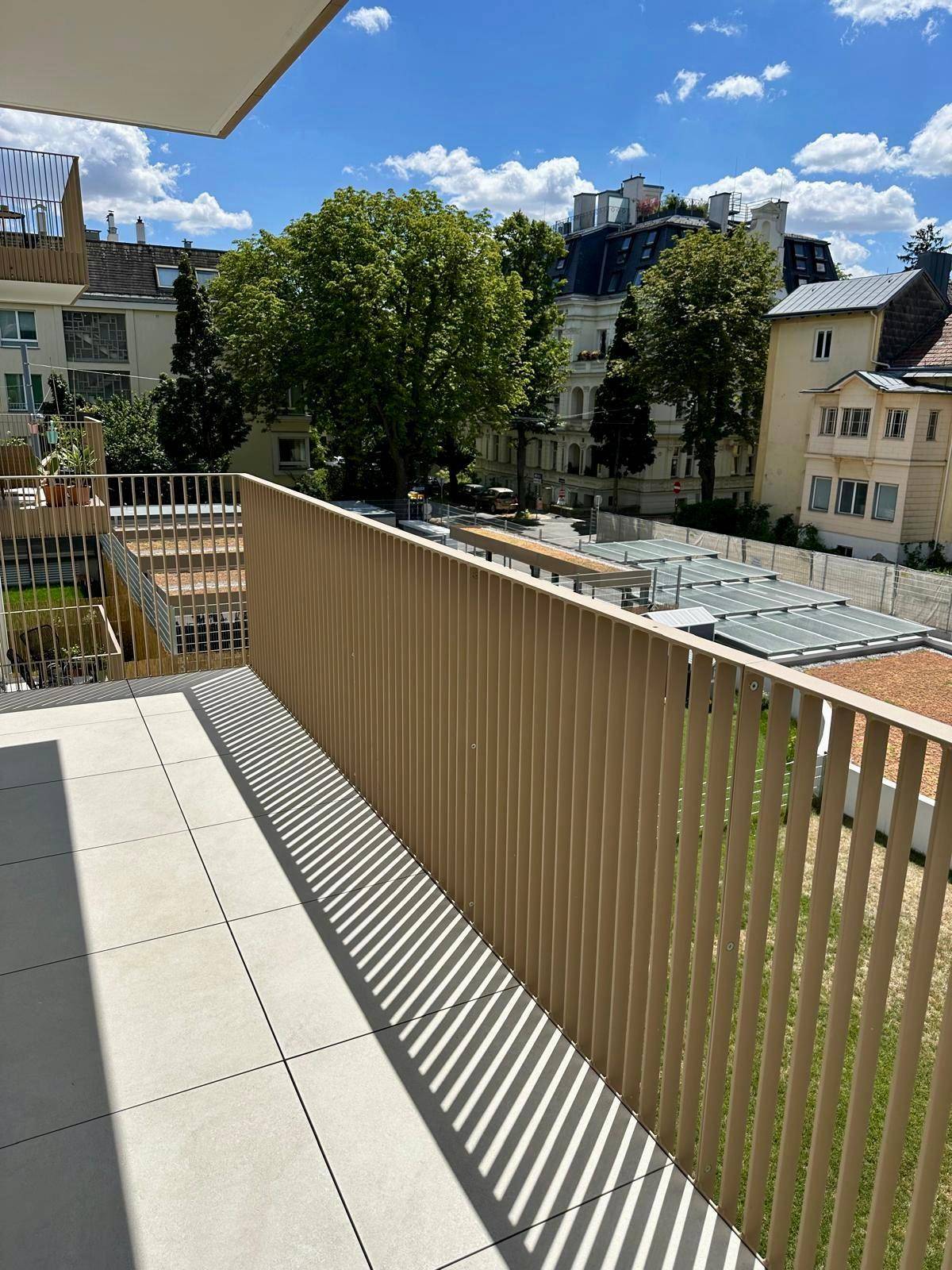 Balkon mit Fliesenboden und Blick auf die Stadt und umliegende Gebäude.
