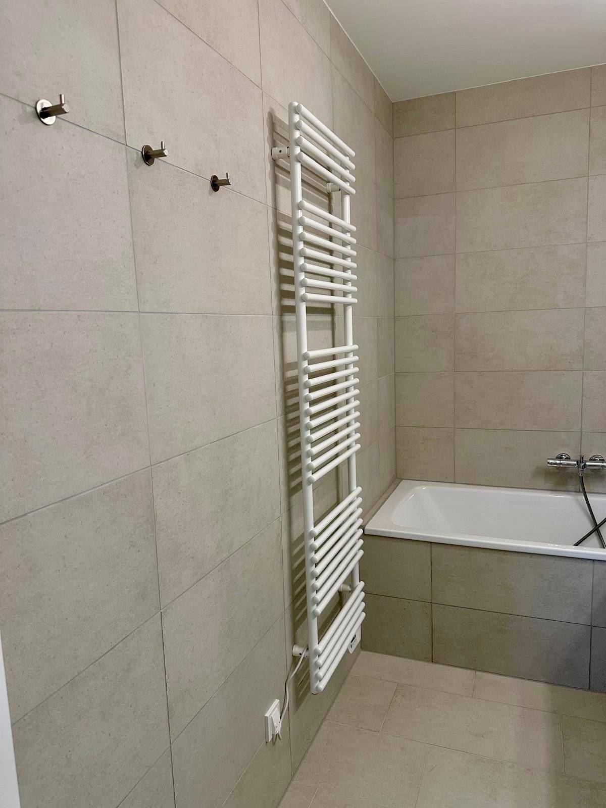Detailansicht des beheizten Handtuchhalters im modernen Badezimmer.