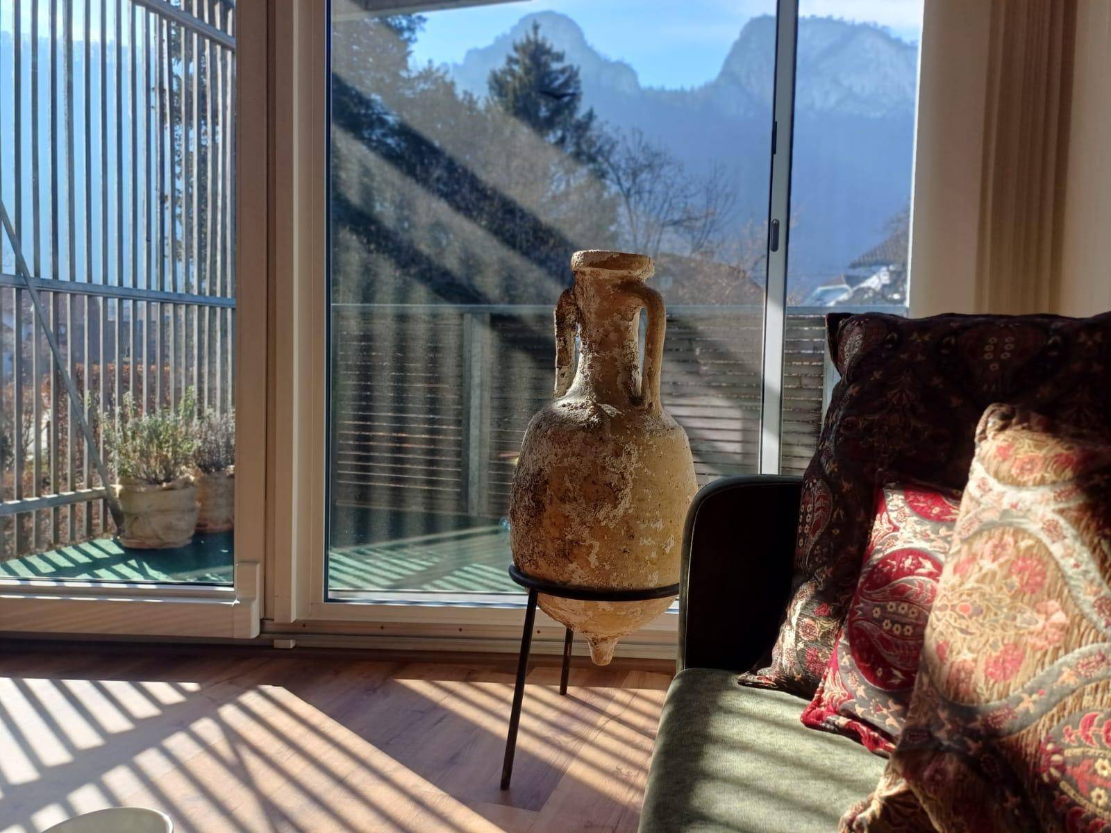 Helles Wohnzimmer mit großen Glasfronten und weitem Bergblick von der Terrasse.