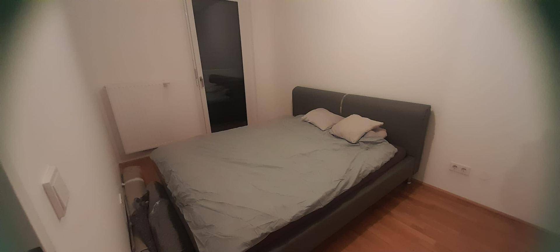 Schlafzimmer mit einem Doppelbett und einem Heizkörper an der Wand.