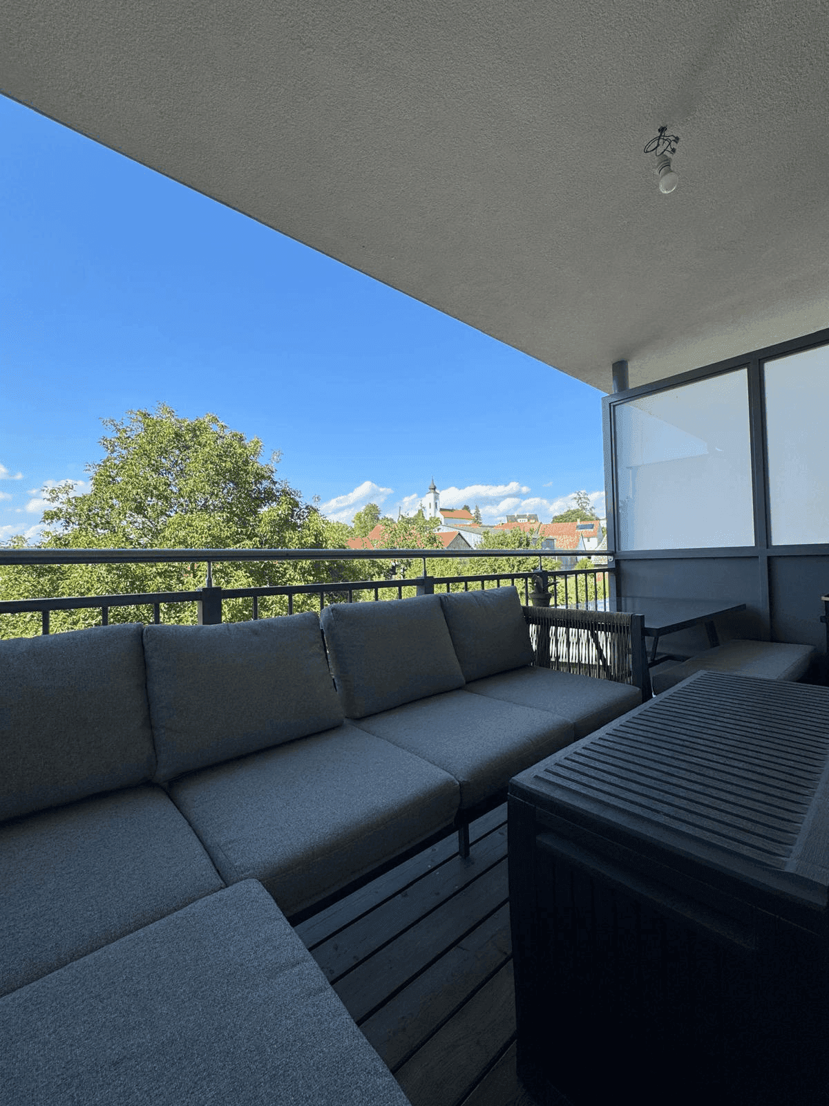 Geräumiger Balkon mit bequemen Outdoor-Möbeln und Blick auf die Umgebung.