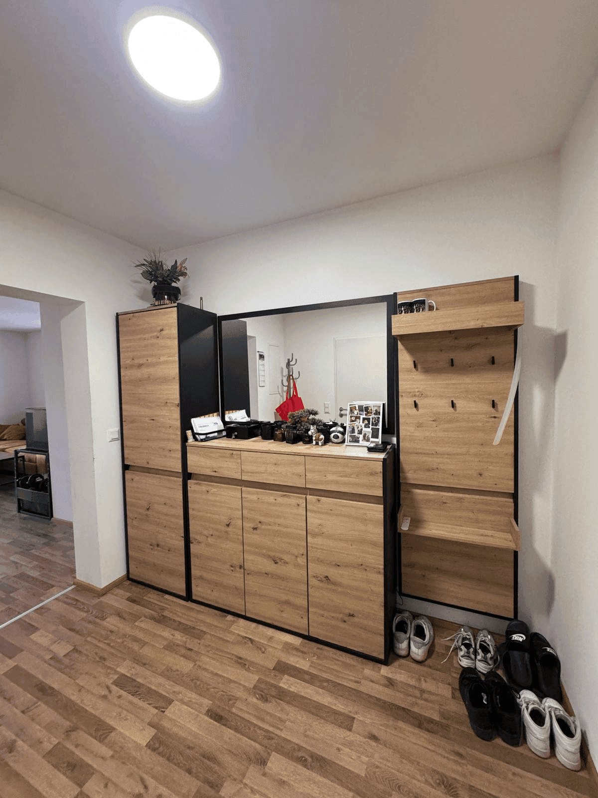 Heller Flur mit modernem Garderobenschrank und Spiegel.