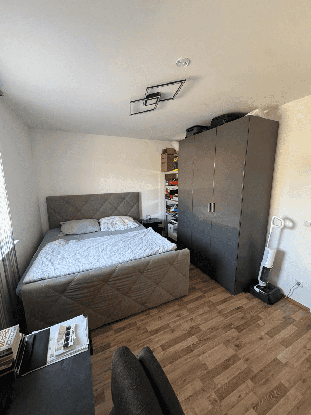 Schlafzimmer mit Doppelbett, Kleiderschrank und Holzboden.