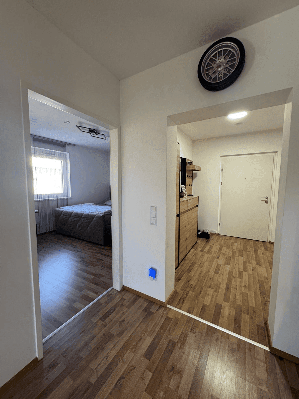 Flur mit Holzboden, der zu Schlafzimmer und Eingangsbereich führt.