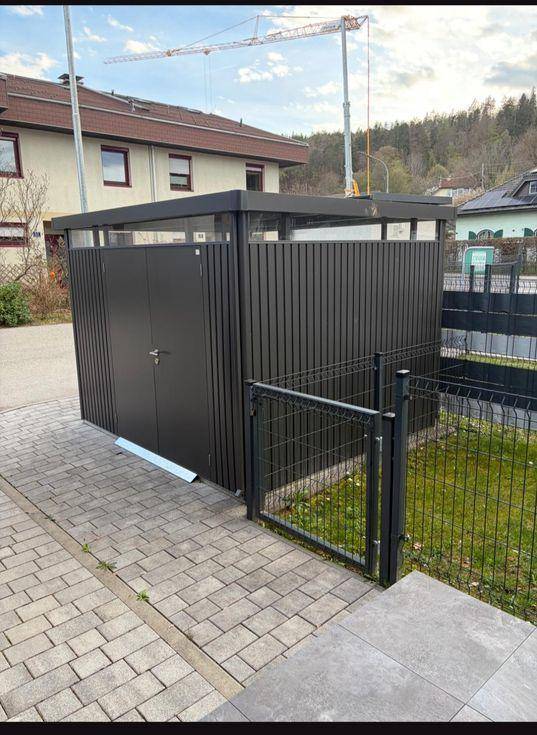 Moderner Abstellraum oder Fahrradschuppen mit Metallverkleidung und abschließbaren Türen.