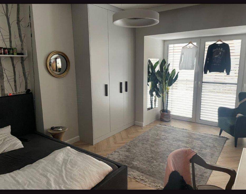 Gemütliches Schlafzimmer mit großem Kleiderschrank, Teppich und viel Tageslicht durch das Fenster.