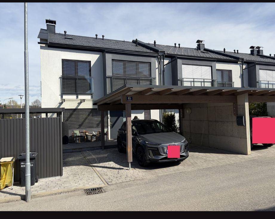 Reihe moderner Reihenhäuser mit Carports und gepflegter Außenanlage.