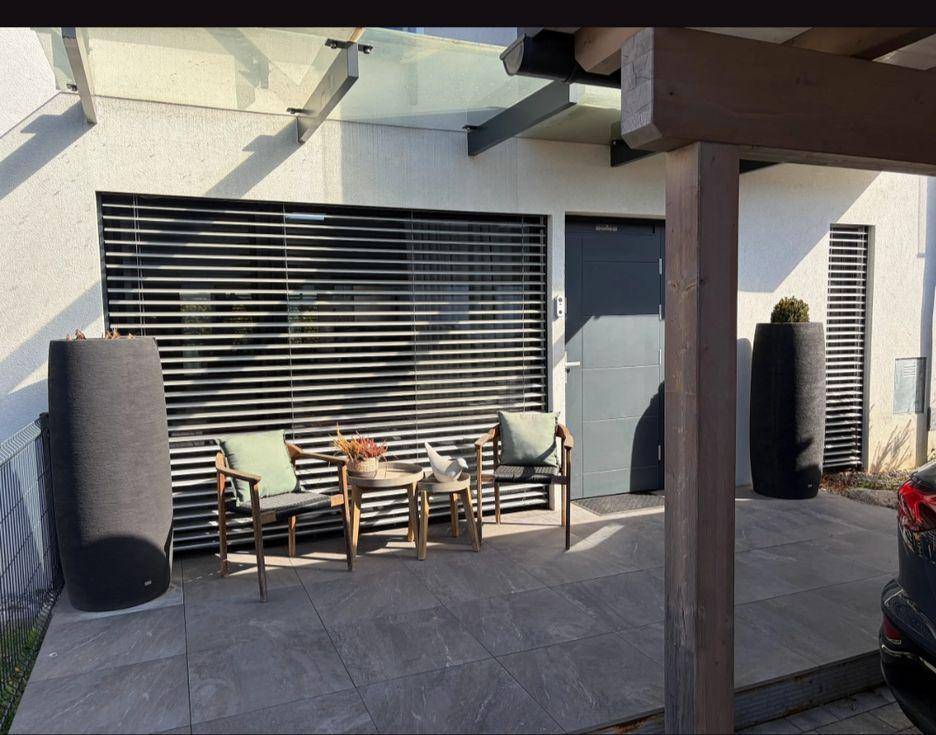 Gemütliche Terrasse mit Sitzgelegenheiten, Überdachung und Zugang zum Haus.