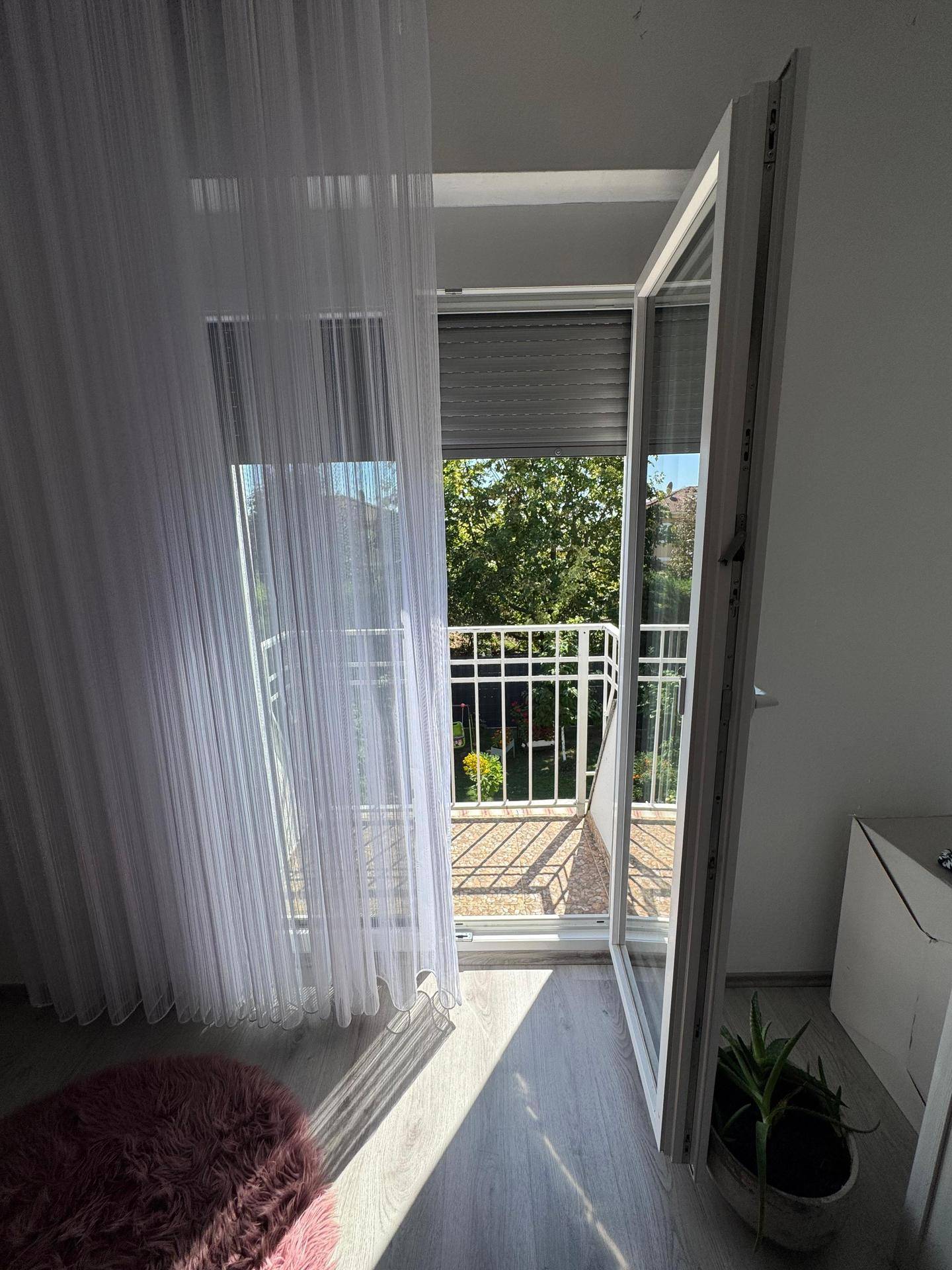 Helles Schlafzimmer mit Zugang zum französischen Balkon und Blick ins Grüne.