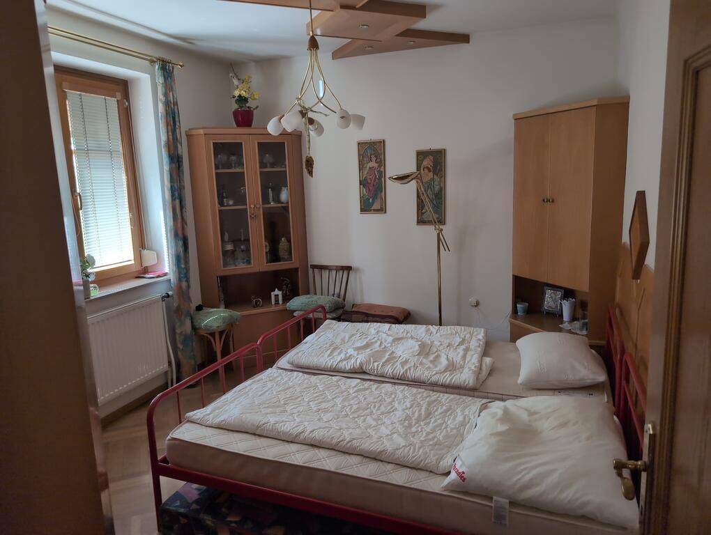 Schlafzimmer mit Einzelbetten, Holzmöbeln und Fenster mit Blick ins Grüne, das viel Licht spendet.