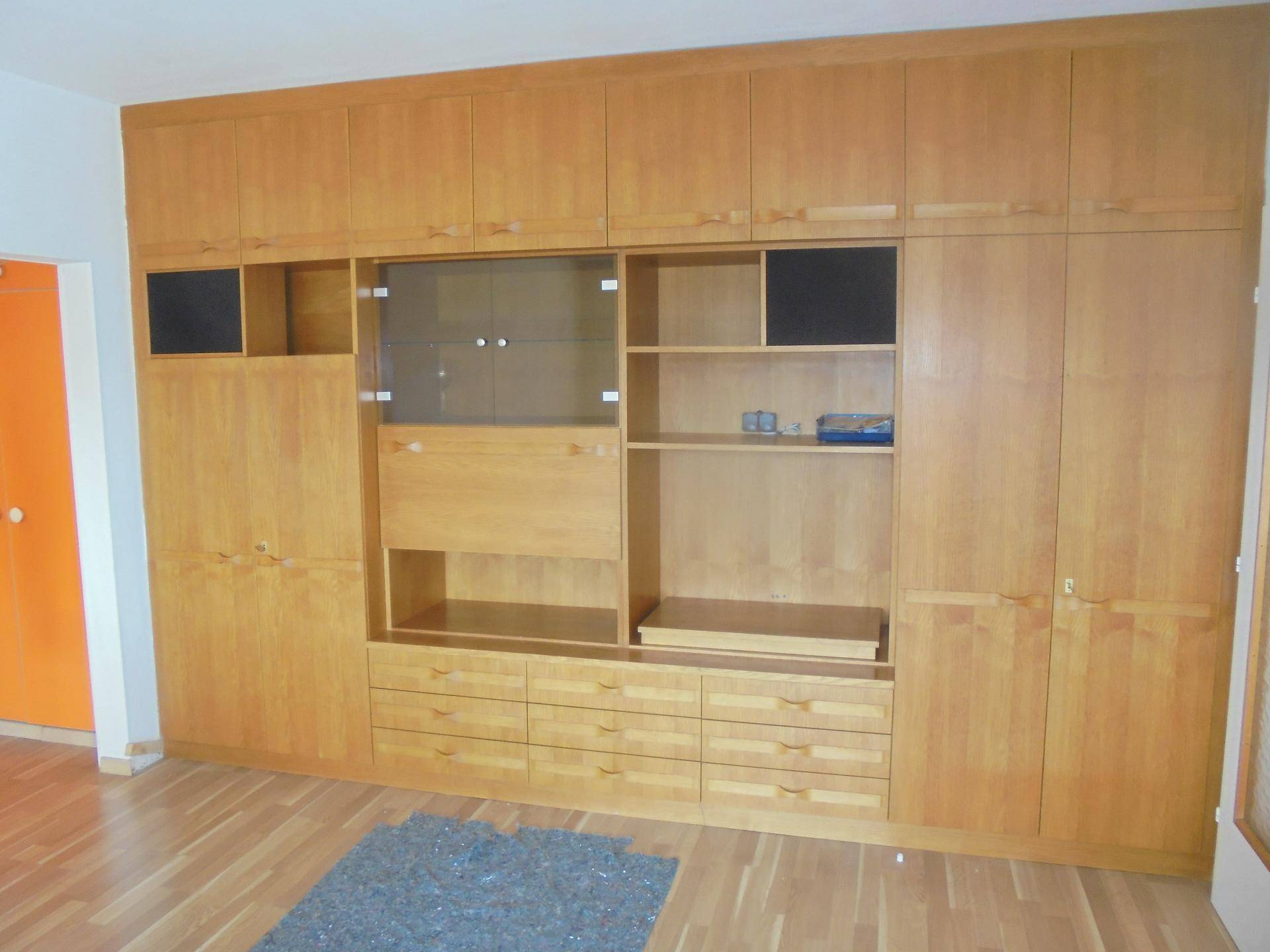 Großer Einbauschrank aus hellem Holz mit viel Stauraum und integrierten Fächern.
