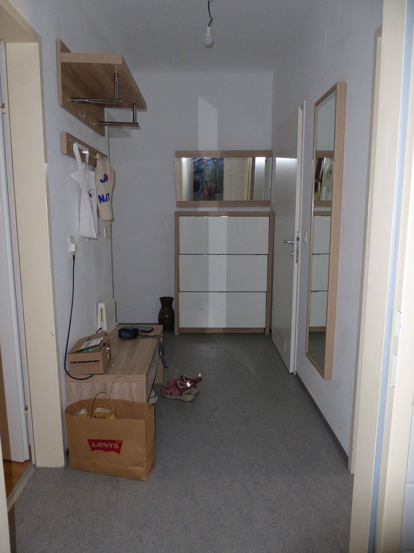 Heller Flur mit Schuhschrank, Spiegel und Garderobe für den Eingangsbereich.