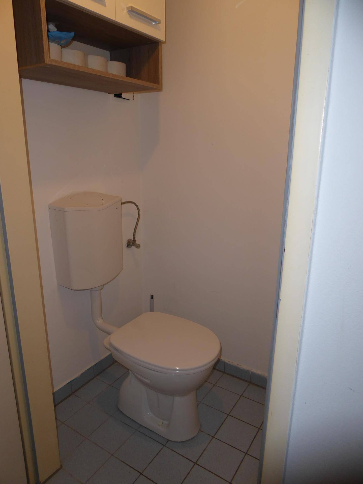 Kleines Gäste-WC mit Toilette und praktischem Hängeschrank.