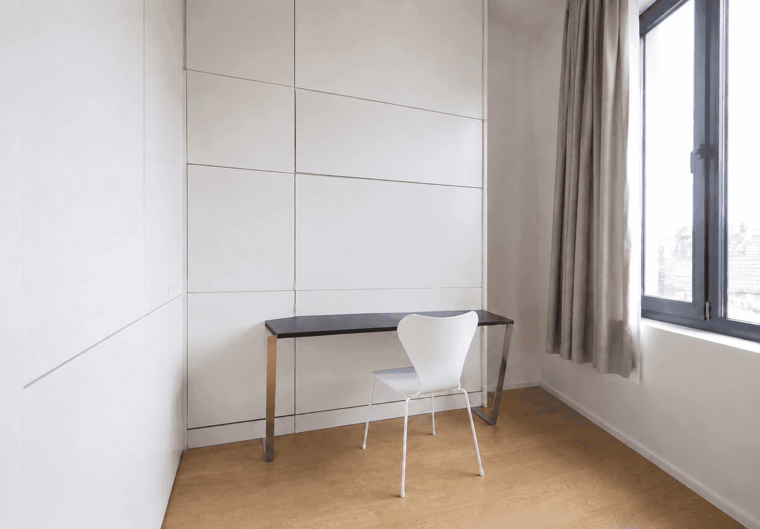 Helles Arbeitszimmer mit integrierten Schränken, modernem Schreibtisch und Fenster.