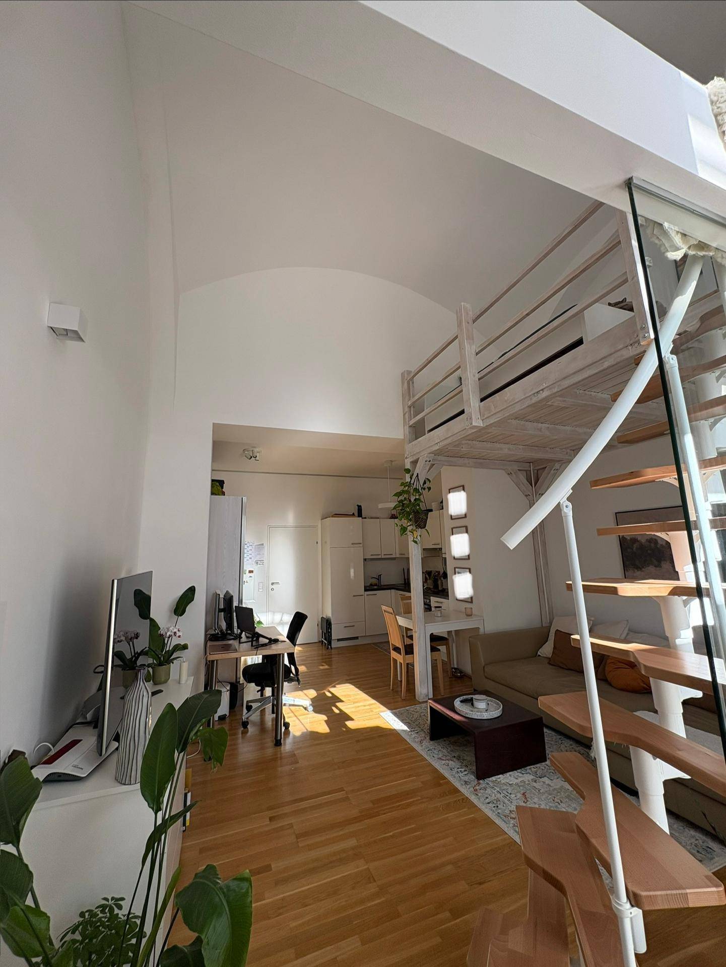 Geräumiger offener Wohnbereich mit hoher Gewölbedecke und einer Holz-Loftstruktur.