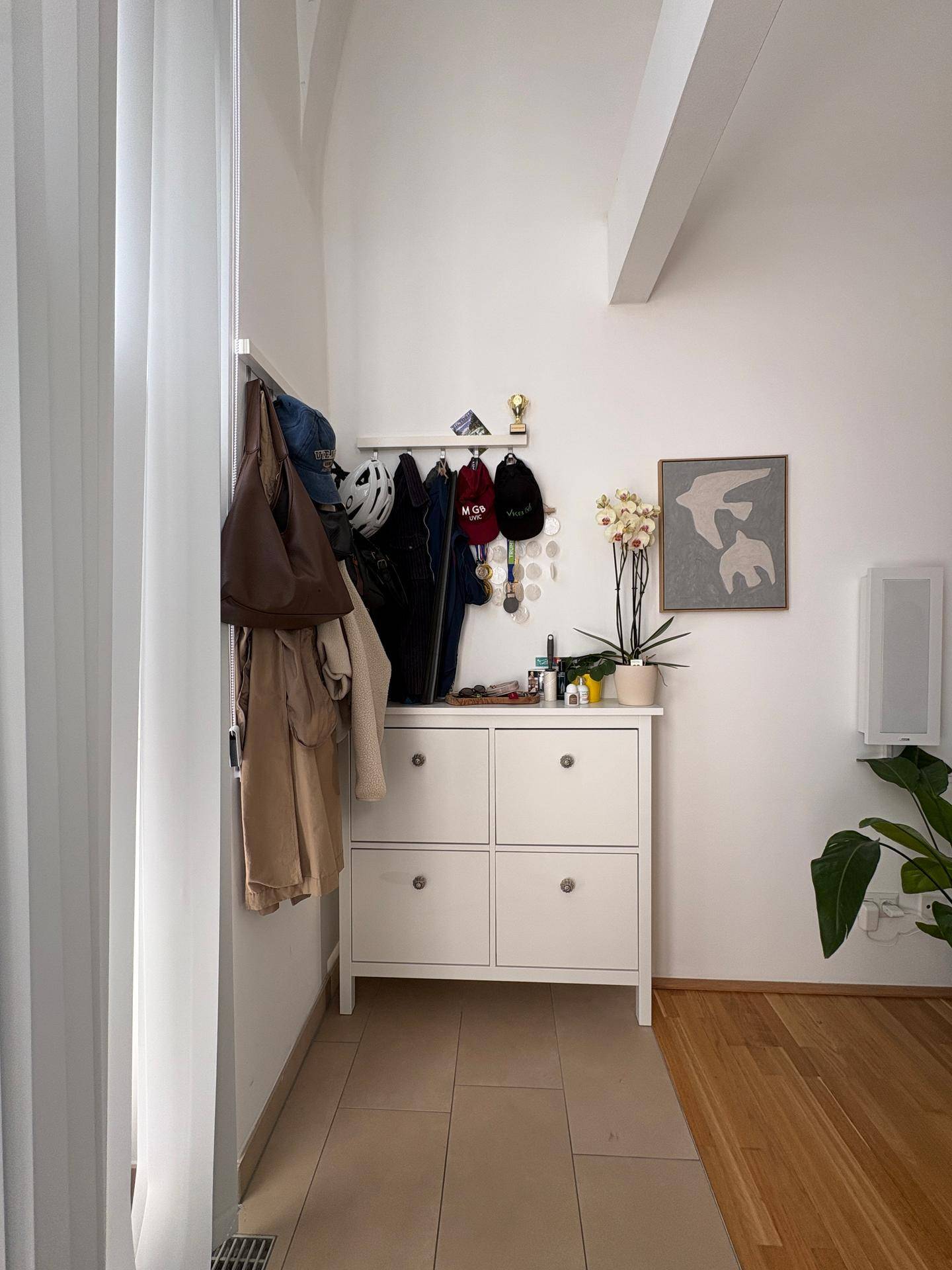 Heller Eingangsbereich mit Schuhschrank und Garderobe, ausgestattet mit Fliesenboden.