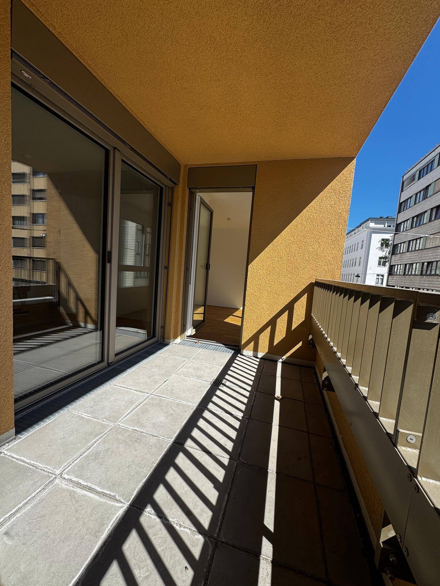 Sonnige Loggia mit Fliesenboden und Zugang zum Innenbereich der Wohnung.
