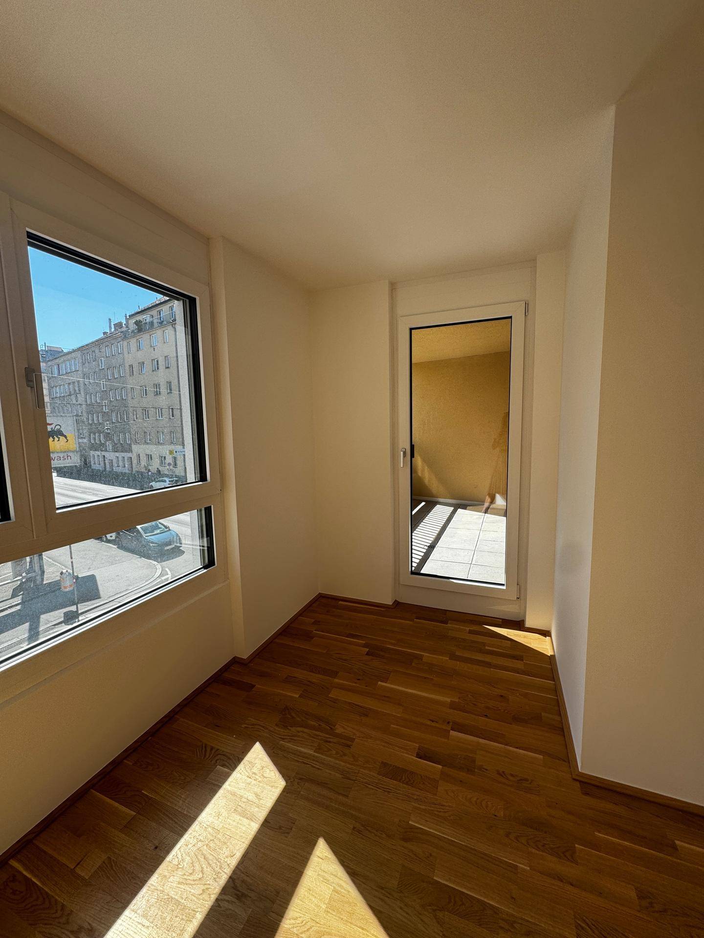Helles Schlafzimmer mit Holzboden, großen Fenstern und viel Tageslicht.
