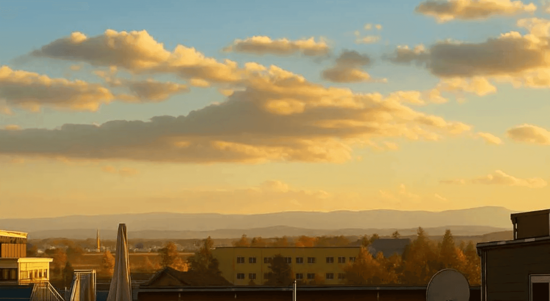 Malerischer Sonnenuntergang über einer weiten Landschaft mit Bergen und Gebäuden am Horizont.