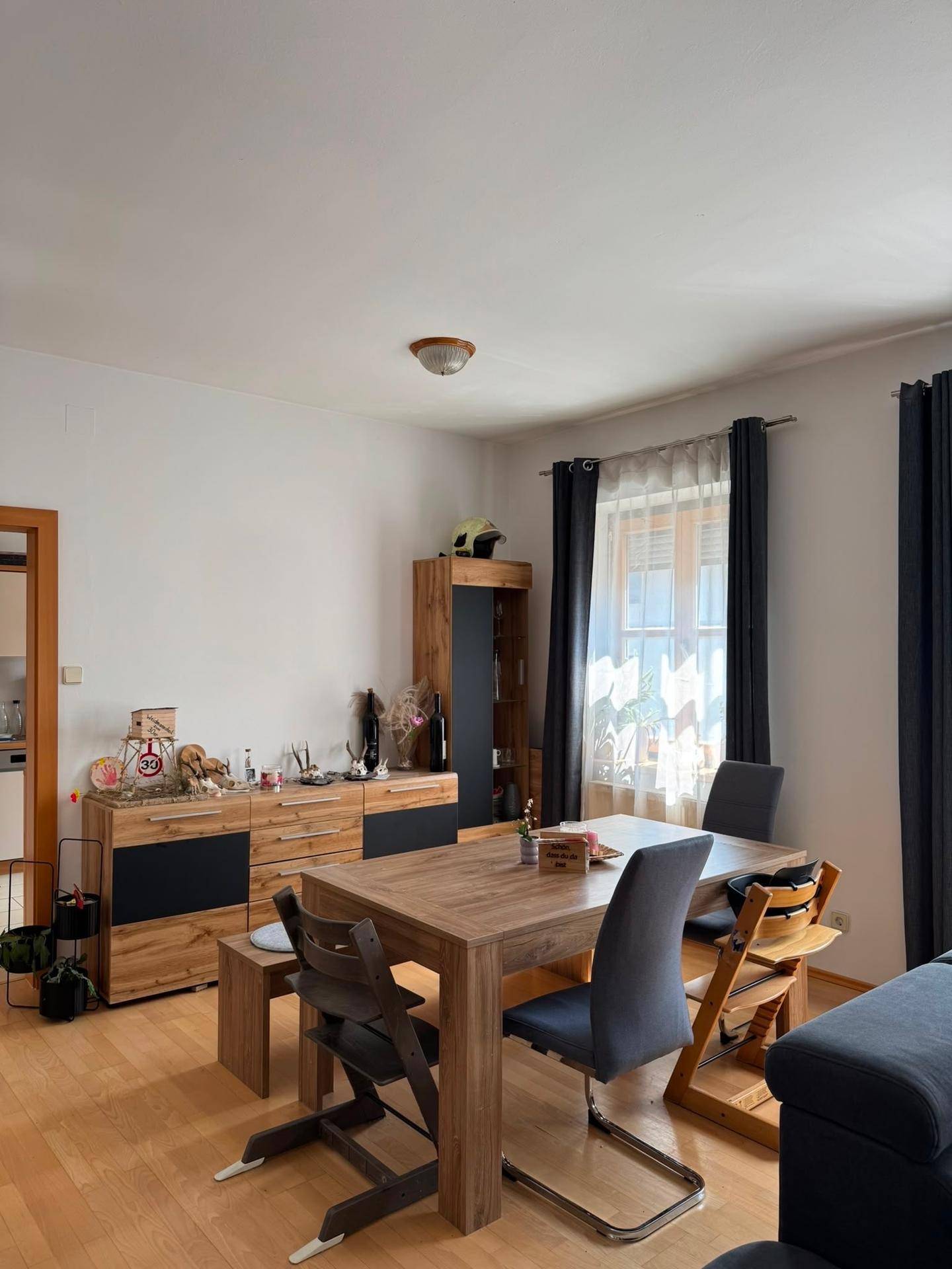 Heller Essbereich mit Holztisch, passenden Stühlen und einem Sideboard, ideal für Familienmahlzeiten.