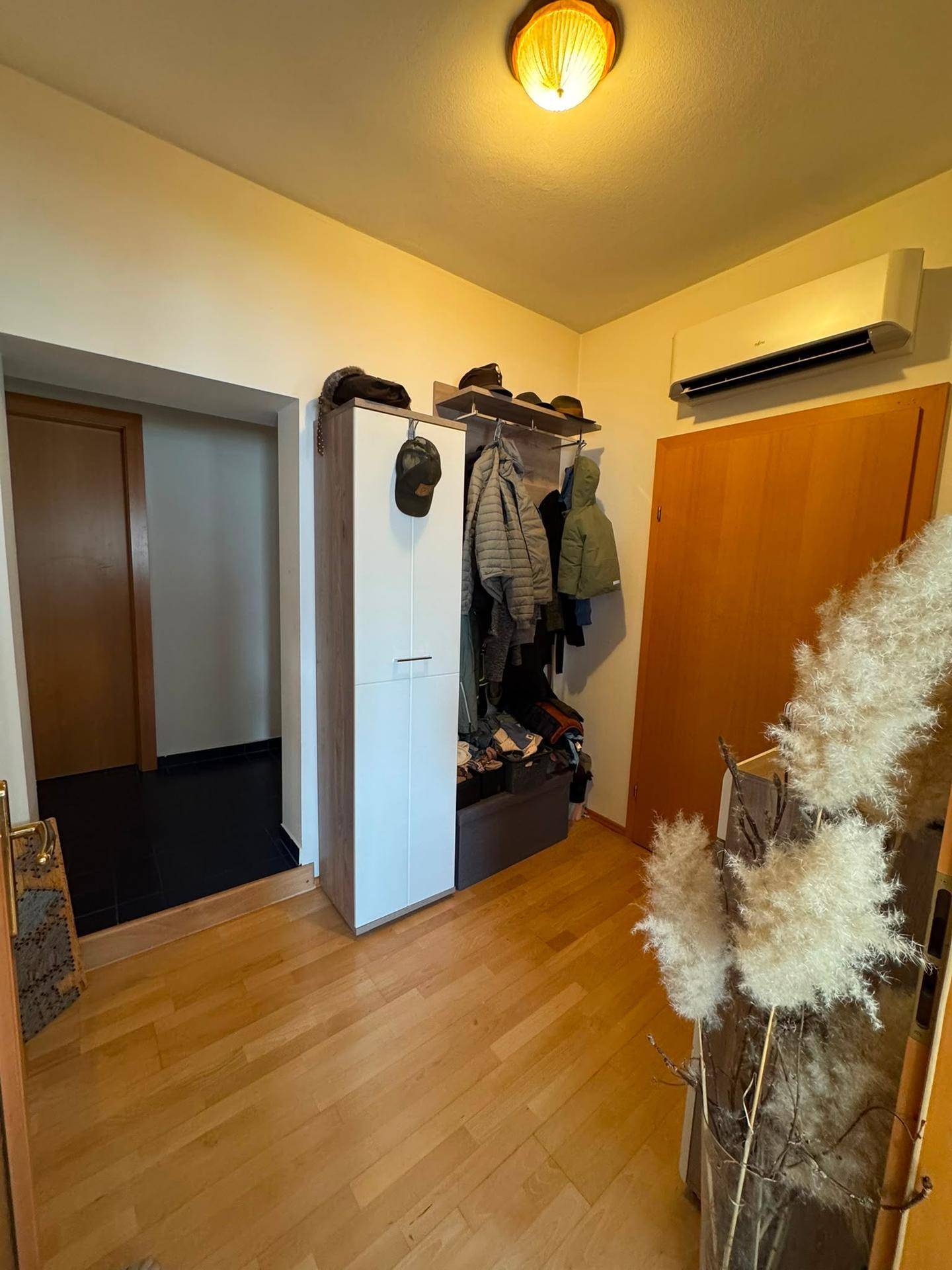 Eingangsbereich mit Garderobe, Schrank und Klimaanlage, bietet praktischen Stauraum.