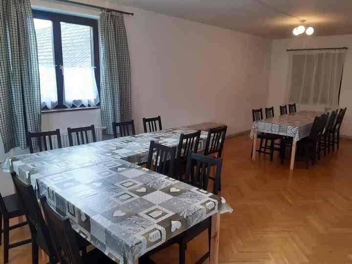 Großer Essbereich mit mehreren Tischen und Stühlen, ideal für Gruppen.